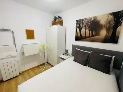 a bedroom with a white bed and a painting on the wall at Beach Apartment Barca 6 in Sant Adria de Besos