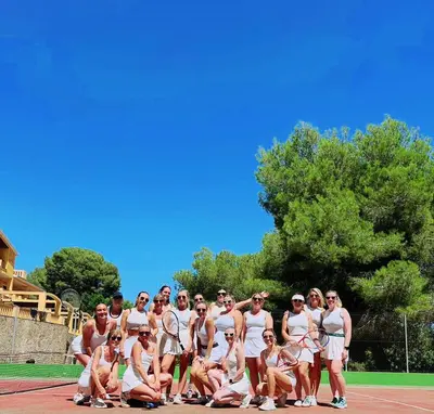 a group of people posing for a picture on a tennis court at Villa Golf Sitges in Vilanova i la Geltrú