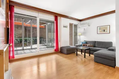 a living room with a couch and a large window at Sunny Terrace Retreat AC 3BR2BA in Barcelona