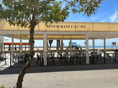 a restaurant with tables and chairs in front of the beach at Cunit, front line with sea view in Cunit