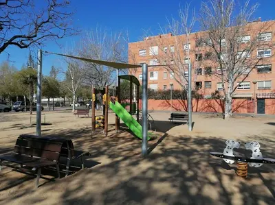 a playground with a green slide in a park at Piso pl 2B, 20min Plaza Cataluña in Sant Adria de Besos