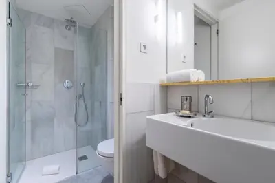 a bathroom with a shower and a sink and a toilet at Aspasios City Oasis Apartments in Barcelona