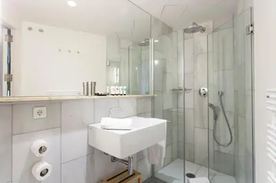 a white bathroom with a sink and a shower at Aspasios City Oasis Apartments in Barcelona