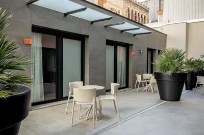 a patio with a table and chairs and plants at Europa Apartments in Hospitalet de Llobregat