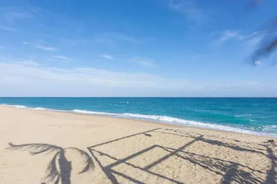 a shadow of two people on the beach at HomeHolidaysRentals Aquilone - Costa Barcelona in Pineda de Mar