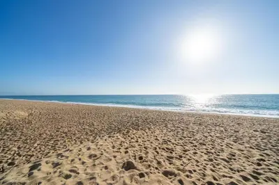 a sandy beach with the ocean in the background at HomeHolidaysRentals Aquilone - Costa Barcelona in Pineda de Mar
