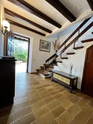 a hallway with stairs in a house with a tile floor at Cal Poldo in Marganell