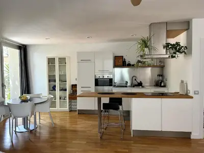 a kitchen with white cabinets and a table and chairs at Loft Bouquet Alella mar y montaña 25 min a BCN in Alella
