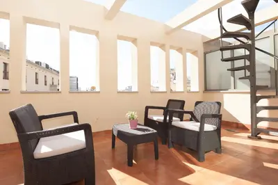 a room with four chairs and a spiral staircase at LetsGo Paseo de Gracia in Barcelona