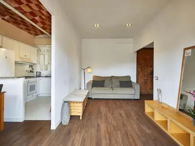 a living room with a couch and a kitchen at Bed&BCN Arquimedes Barcelona in Barcelona