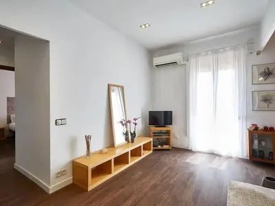 a living room with a table and a tv in it at Bed&BCN Arquimedes Barcelona in Barcelona