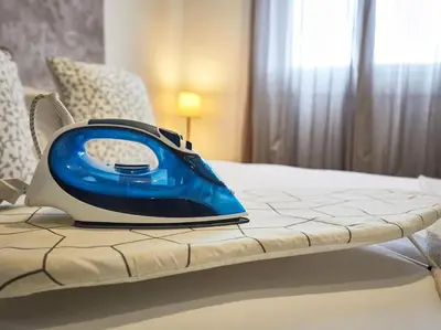 a blue iron sitting on top of a bed at Bed&BCN Arquimedes Barcelona in Barcelona