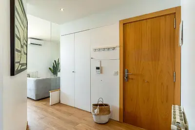 a hallway with a wooden door and white cabinets at AB Olympic Village III Penthouse in Barcelona