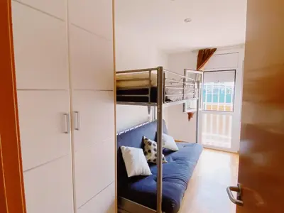 a room with a bunk bed and a blue couch at Sunset Bay Vilanova in Vilanova i la Geltrú