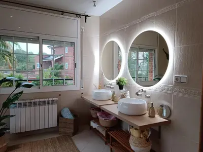 a bathroom with two sinks and two mirrors at Villa Brisas - Preciosa villa con gran intimidad y piscina in Segur de Calafell