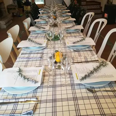 a long table with plates and wine glasses on it at L'Olivera Casa Rural in Castellbisbal