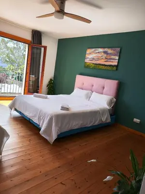 a bedroom with a large bed with a pink headboard at L'Olivera Casa Rural in Castellbisbal