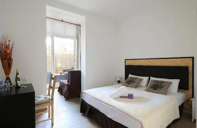 a bedroom with a large white bed and a chair at Hostal Balkonis in Barcelona