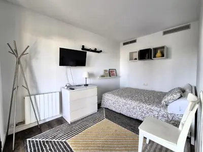 a bedroom with a bed and a flat screen tv at Casa Elena Maresme in Mataró