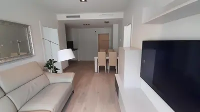 a living room with a couch and a flat screen tv at New beside Sitges with pool beside beach in Vilanova i la Geltrú
