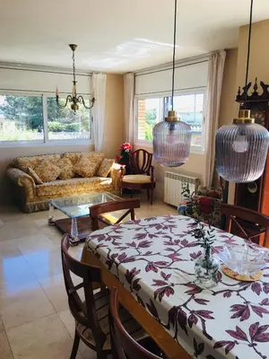 a living room with a table and a couch at Casa de Aurora in Rubí