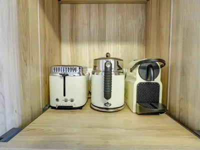 three appliances sitting on a shelf in a cabinet at Paradise Apartment by Hello Homes Sitges in Sitges
