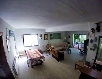 a living room with a table and a couch at Apartamento - jardín en playa San Sebastian in Sitges