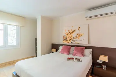 a bedroom with a large white bed with red pillows at AB San Mariano - Park Guell in Barcelona