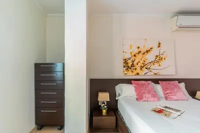 a bedroom with a bed with two pink pillows at AB San Mariano - Park Guell in Barcelona