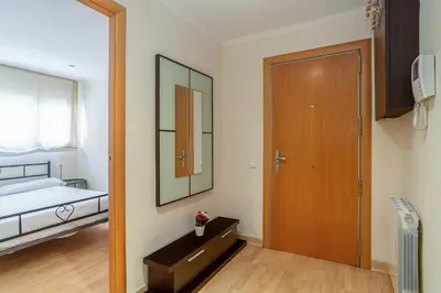 a bedroom with a bed and a wooden door at AB San Mariano - Park Guell in Barcelona