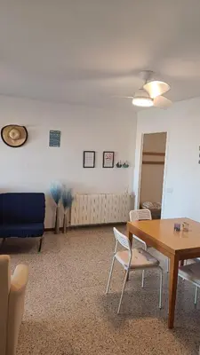 a room with a table and chairs and a couch at Canet playa y centro con free wifi in Canet de Mar