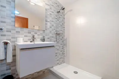 a white bathroom with a sink and a mirror at Hauzify I Apartament Ponent in Pineda de Mar