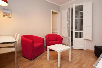 a living room with two red chairs and a table at Enjoy Apartments VP Camp Nou 2 in Barcelona