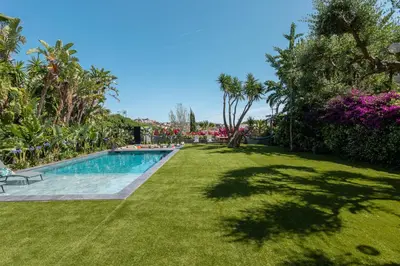 a yard with a swimming pool and green grass at BARCELONA´S TROPICAL OASIS in Sant Just Desvern