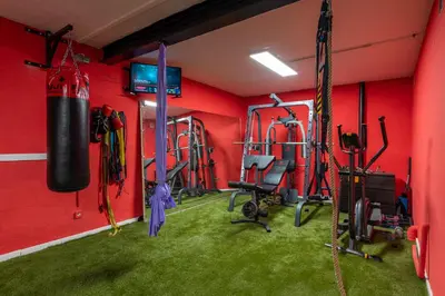 a fitness room with red walls and a gym at BARCELONA´S TROPICAL OASIS in Sant Just Desvern