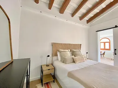 a white bedroom with a bed and a desk at Historic House at Can Quintana by Casa de Elena in Pineda de Mar