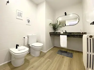 a bathroom with a toilet and a sink and a mirror at Historic House at Can Quintana by Casa de Elena in Pineda de Mar