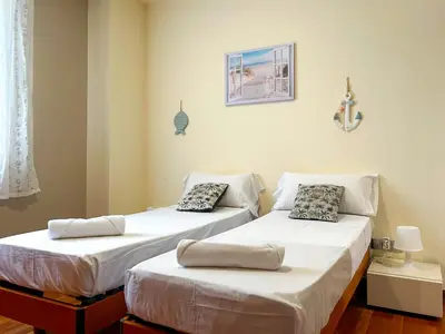 two beds sitting next to each other in a room at Apt Mediterreanea Parking Terrazza Netflix Hostem in Vilanova i la Geltrú