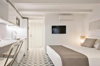 a white bedroom with a bed and a sink at Uma Suites Sagrada Familia in Barcelona