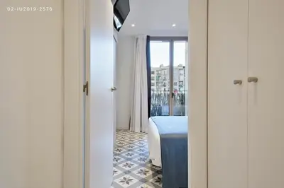a bedroom with a bed and a view of a window at Uma Suites Sagrada Familia in Barcelona