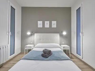 a white bedroom with a bed with towels on it at Gran Via Terrace Barcelona in Barcelona