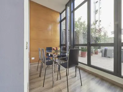 a dining room with a glass table and chairs at Gran Via Terrace Barcelona in Barcelona
