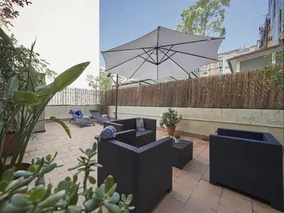 a patio with an umbrella and some chairs andisks at Gran Via Terrace Barcelona in Barcelona