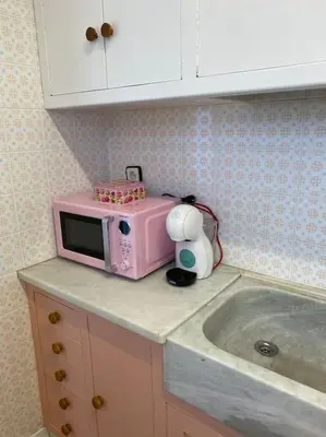 a pink microwave sitting on top of a kitchen counter at Casita pueblo al lado Del Mar-Vilasardemarlux4 in Vilassar de Mar