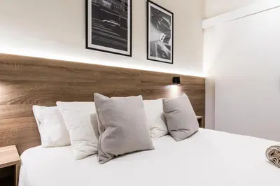 a bedroom with a white bed with white pillows at Exclusive Apartments Barcelona 4 personas St Pere in Terrassa