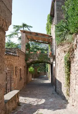 an alley with an archway between two brick buildings at APARTAMENTS PUIG GILI in Mura