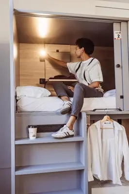 a woman sitting on top of a bunk bed at Leevin Student Barcelona in Barcelona