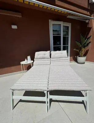 a white bed sitting outside of a building at Wonderful house near Barcelona in Castelldefels