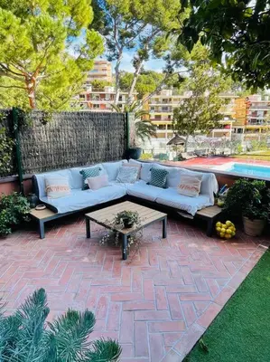 a blue couch sitting on a brick patio next to a pool at Wonderful house near Barcelona in Castelldefels