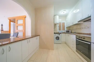 a kitchen with white cabinets and a washer and dryer at HomeHolidaysRentals Estrella - Costa Barcelona in Pineda de Mar